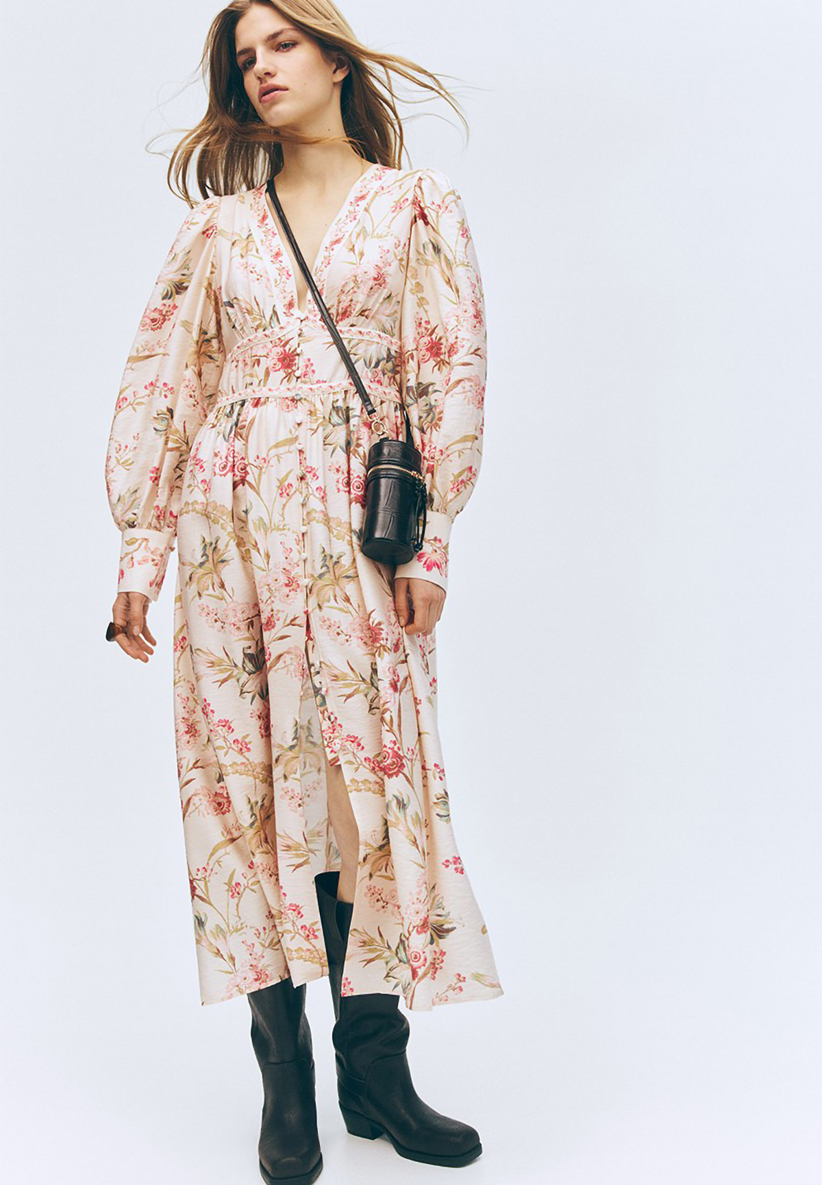 Woman in a blush floral maxi dress with a deep V-neck and balloon sleeves