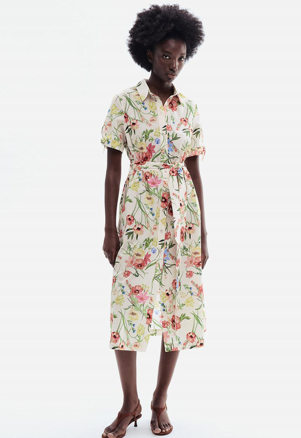 Woman in a cream, watercolour-floral collared shirt dress, belted at the waist